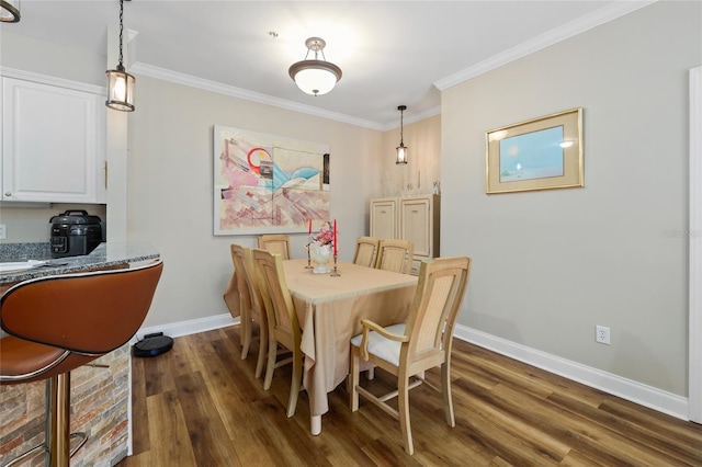 dining room featuring ornamental molding and dark hardwood / wood-style floors