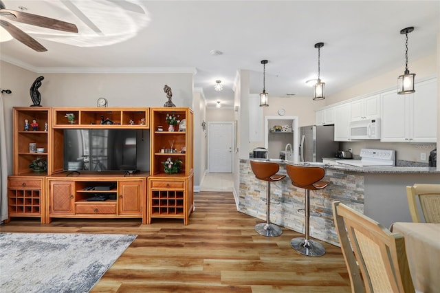 interior space featuring white appliances, light wood-type flooring, ceiling fan, decorative light fixtures, and white cabinets