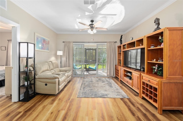 living room with light hardwood / wood-style floors, ornamental molding, and ceiling fan