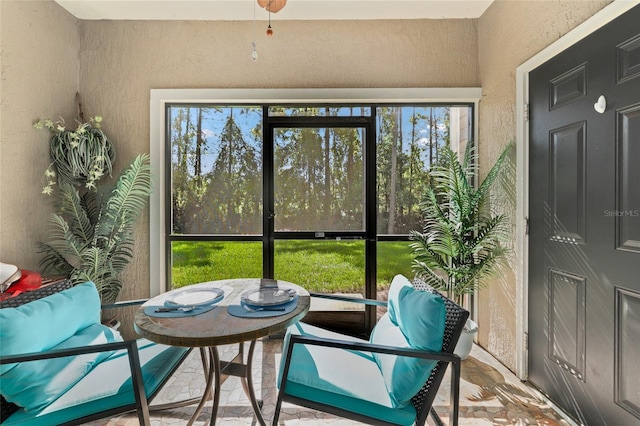 sunroom featuring ceiling fan