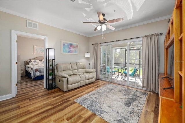 living room with ornamental molding, wood-type flooring, and ceiling fan