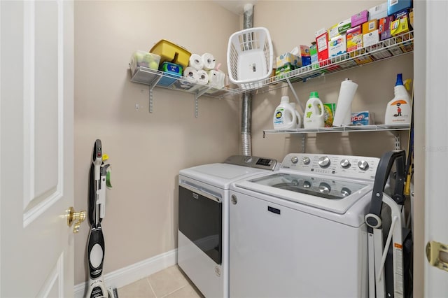 laundry room with washer and dryer and light tile patterned floors