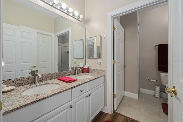 bathroom with vanity, tile patterned floors, toilet, and an enclosed shower