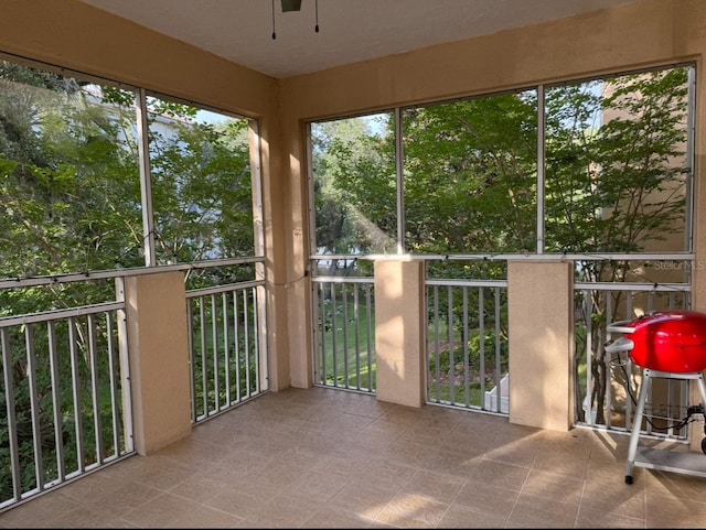 unfurnished sunroom featuring ceiling fan