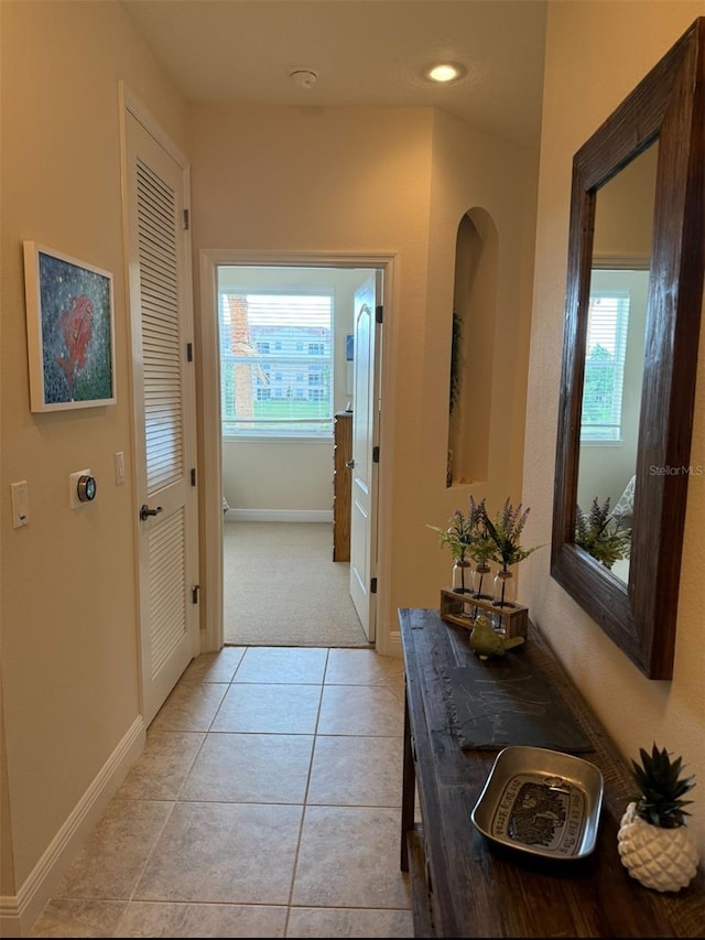 corridor featuring light tile patterned floors and a wealth of natural light