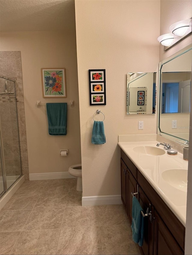 bathroom with an enclosed shower, vanity, tile patterned flooring, and toilet