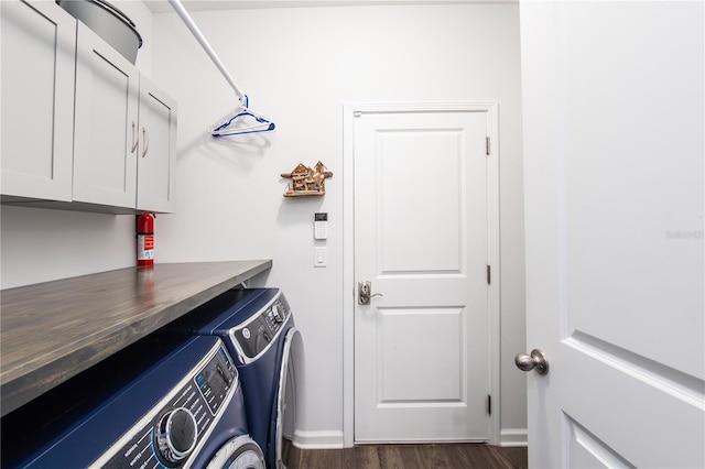 laundry area with washing machine and dryer, cabinets, and dark hardwood / wood-style floors