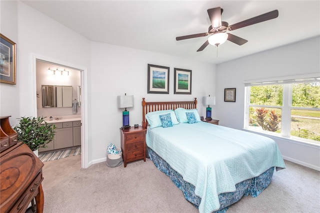 carpeted bedroom with ensuite bath and ceiling fan