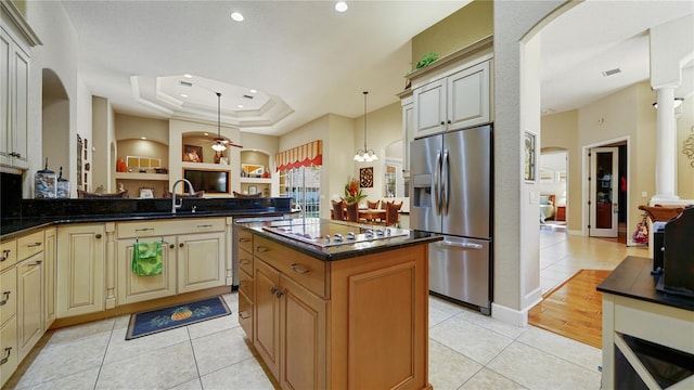 kitchen with a kitchen island, hanging light fixtures, stainless steel fridge, cooktop, and light tile patterned floors