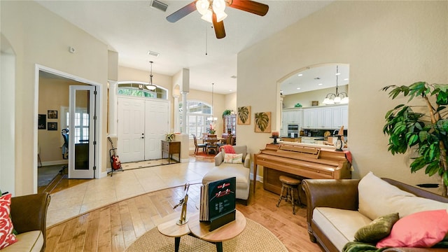 living room with light hardwood / wood-style flooring and ceiling fan with notable chandelier