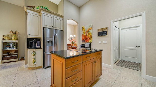 kitchen featuring light tile patterned floors, stainless steel fridge with ice dispenser, black electric cooktop, and a kitchen island