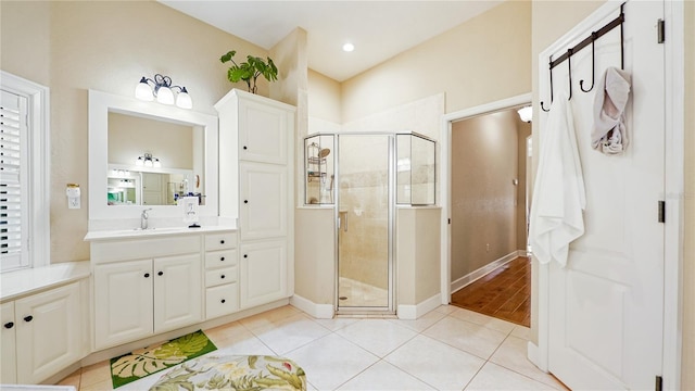 bathroom with vanity, a shower with shower door, and tile patterned floors