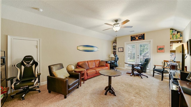 living room with ceiling fan, a textured ceiling, vaulted ceiling, french doors, and light colored carpet