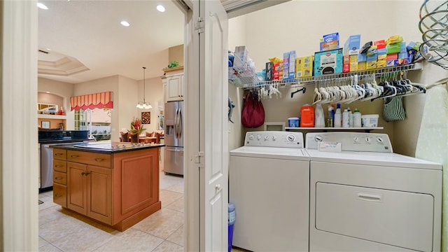 washroom featuring an inviting chandelier, separate washer and dryer, and light tile patterned floors