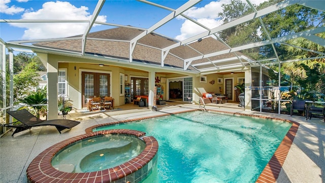 view of pool with french doors, a patio area, glass enclosure, and an in ground hot tub