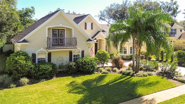 view of front of property featuring a balcony and a front lawn