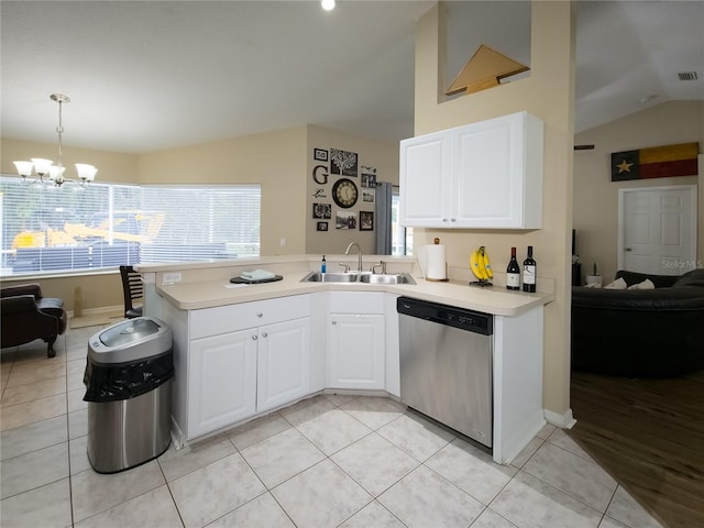 kitchen featuring lofted ceiling, hanging light fixtures, sink, stainless steel dishwasher, and white cabinetry