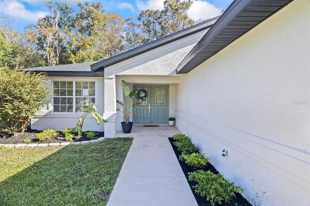 property entrance featuring covered porch and a lawn