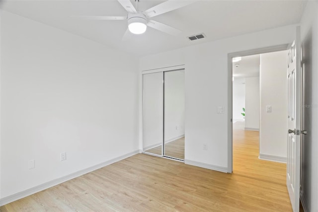 unfurnished bedroom with a closet, light hardwood / wood-style floors, and ceiling fan