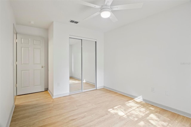 unfurnished bedroom featuring light hardwood / wood-style floors, a closet, and ceiling fan