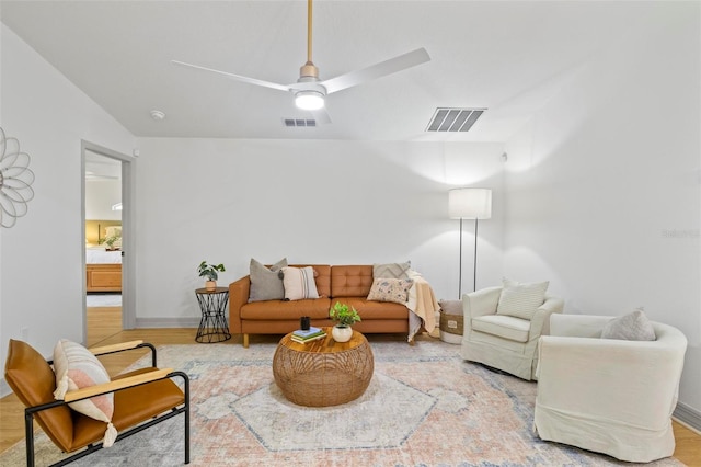 living room with ceiling fan, vaulted ceiling, and hardwood / wood-style floors