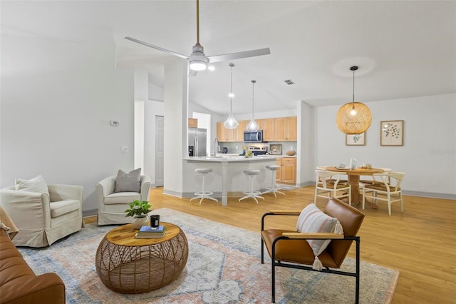 living room with sink, light hardwood / wood-style floors, lofted ceiling, and ceiling fan