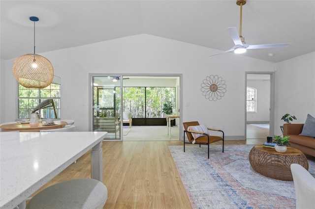 living room featuring vaulted ceiling, light wood-type flooring, and ceiling fan