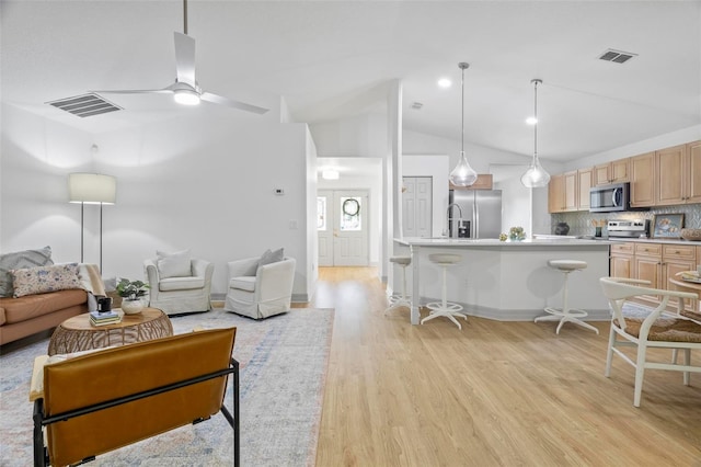 living room featuring lofted ceiling, light wood-type flooring, and ceiling fan