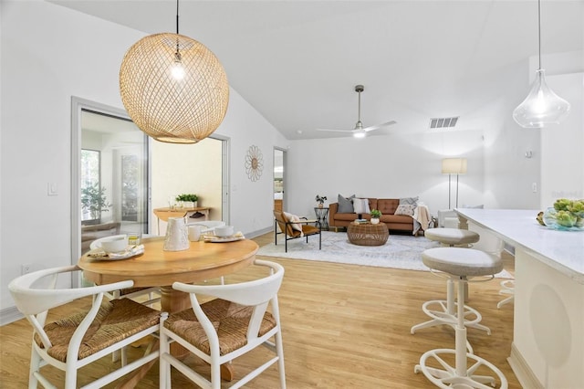 dining space with light hardwood / wood-style floors, lofted ceiling, and ceiling fan