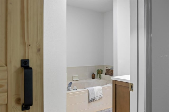 bathroom featuring vanity and a relaxing tiled tub