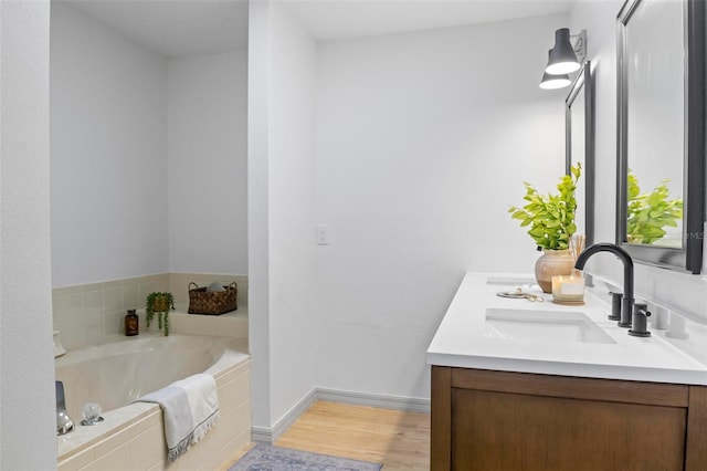 bathroom featuring vanity, hardwood / wood-style flooring, and tiled bath