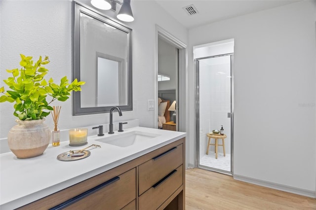 bathroom with vanity, walk in shower, and wood-type flooring