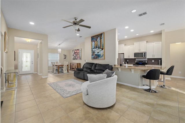 living room with light tile patterned floors, ornate columns, and ceiling fan