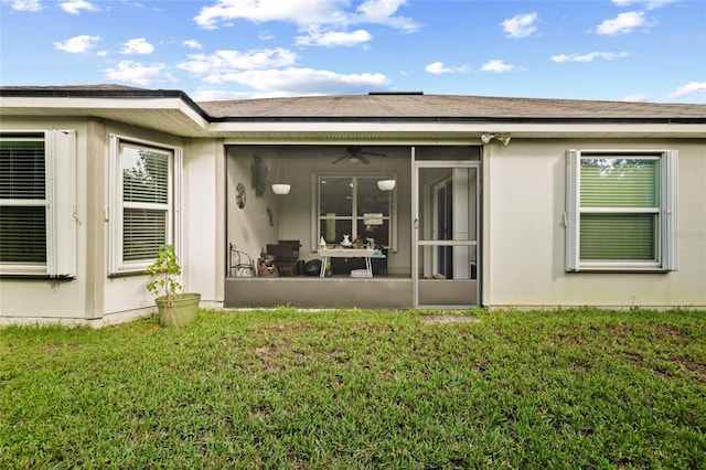 back of property with a yard and a sunroom