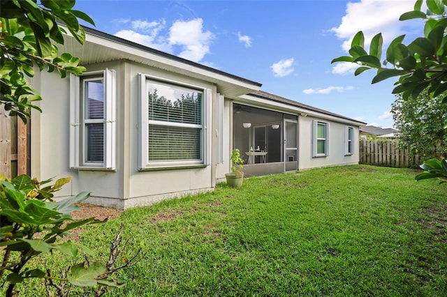 view of side of property featuring a sunroom and a yard