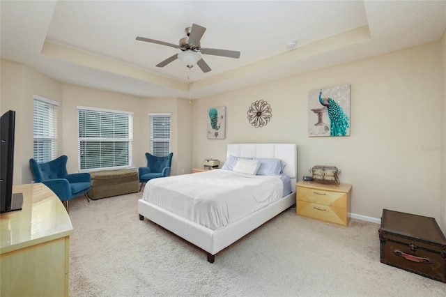 bedroom with carpet floors, a raised ceiling, and ceiling fan