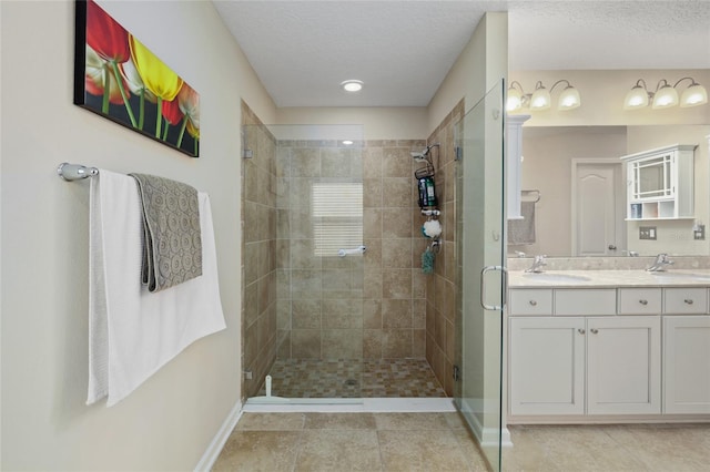 bathroom featuring a textured ceiling, tile patterned flooring, vanity, and an enclosed shower