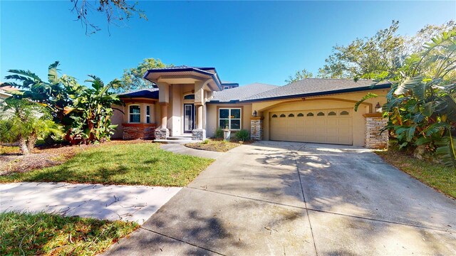 23 Augusta Trl, Palm Coast, FL 32137 - prairie-style home with an attached garage, a front lawn, stucco siding, and concrete driveway