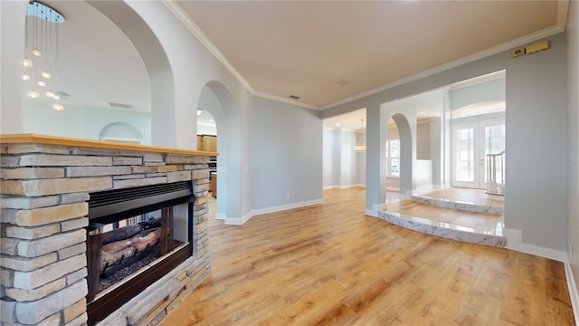 living room featuring light hardwood / wood-style floors, crown molding, and a fireplace