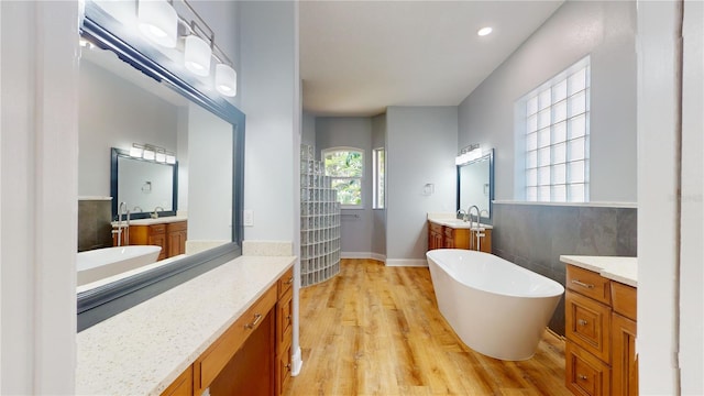 bathroom featuring vanity, a bathtub, hardwood / wood-style flooring, and plenty of natural light