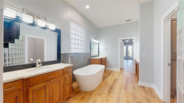 bathroom featuring vanity, wood-type flooring, and a bathing tub