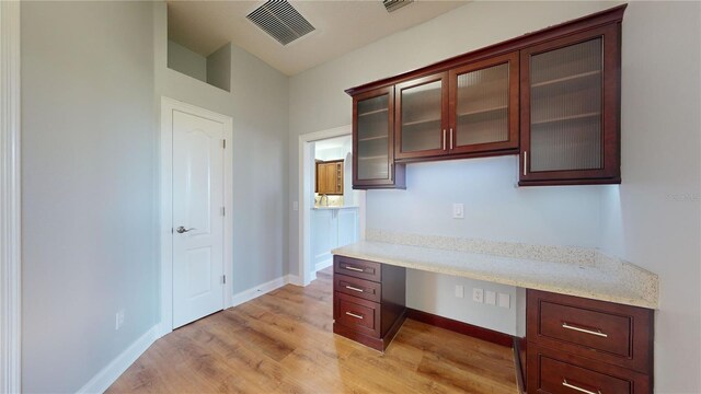 23 Augusta Trl, Palm Coast, FL 32137 - unfurnished office with baseboards, visible vents, built in desk, and light wood-style flooring