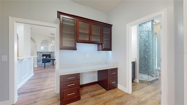 23 Augusta Trl, Palm Coast, FL 32137 - unfurnished office featuring baseboards, a stone fireplace, built in study area, and light wood-style floors