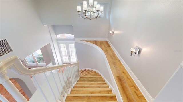 23 Augusta Trl, Palm Coast, FL 32137 - stairs with french doors, wood finished floors, baseboards, an inviting chandelier, and a high ceiling