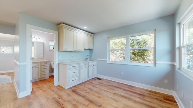 kitchen with sink, light wood-type flooring, and cream cabinetry