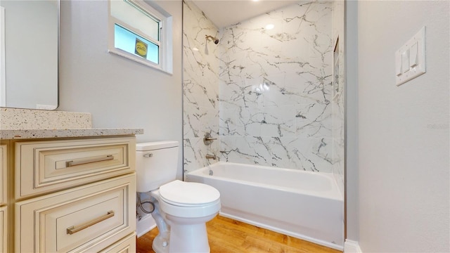 full bathroom with vanity, hardwood / wood-style floors, tiled shower / bath combo, and toilet