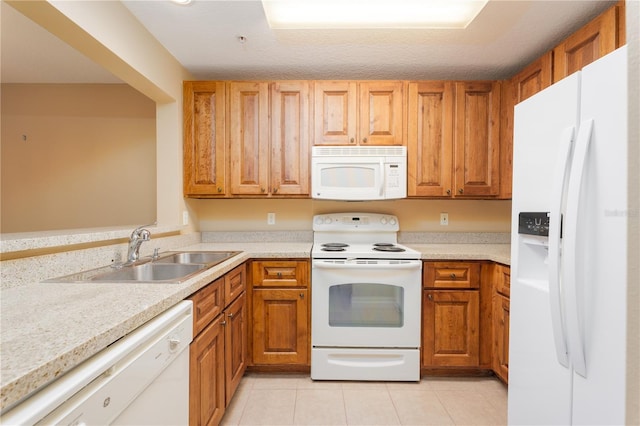 kitchen featuring sink, light tile patterned flooring, a textured ceiling, and white appliances