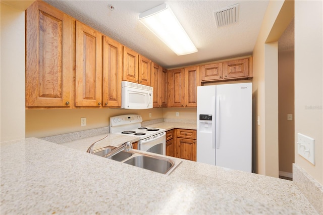 kitchen featuring white appliances, a textured ceiling, and sink