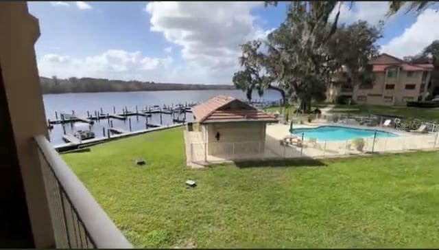 exterior space with a water view, a community pool, and a yard