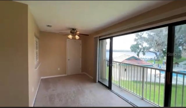 empty room featuring light carpet and ceiling fan